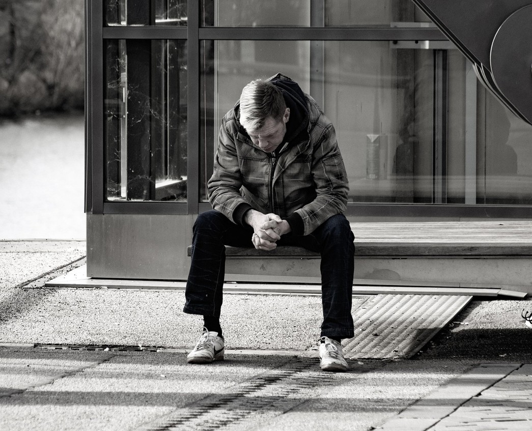 Homme assis seul, tête baissée, symbolisant la dépression, l’épuisement émotionnel et la perte de sens accompagnés en psychothérapie pour adultes à Aubagne.